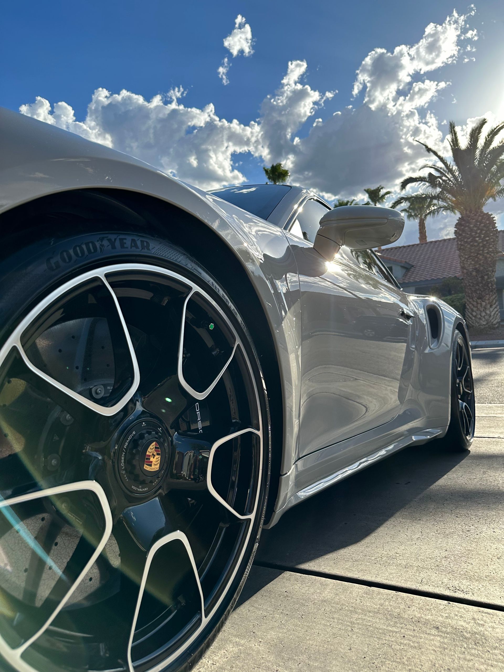 A silver sports car is parked on the side of the road.