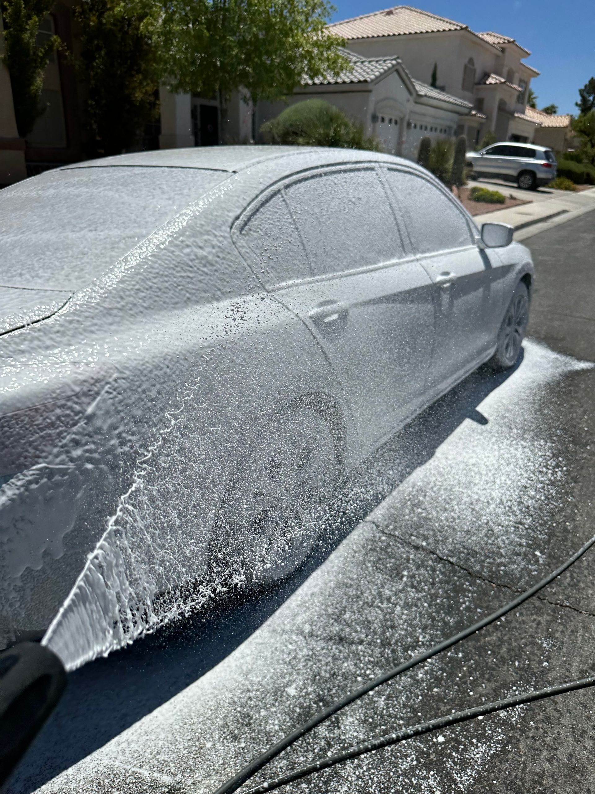 A car is covered in foam on the side of the road.