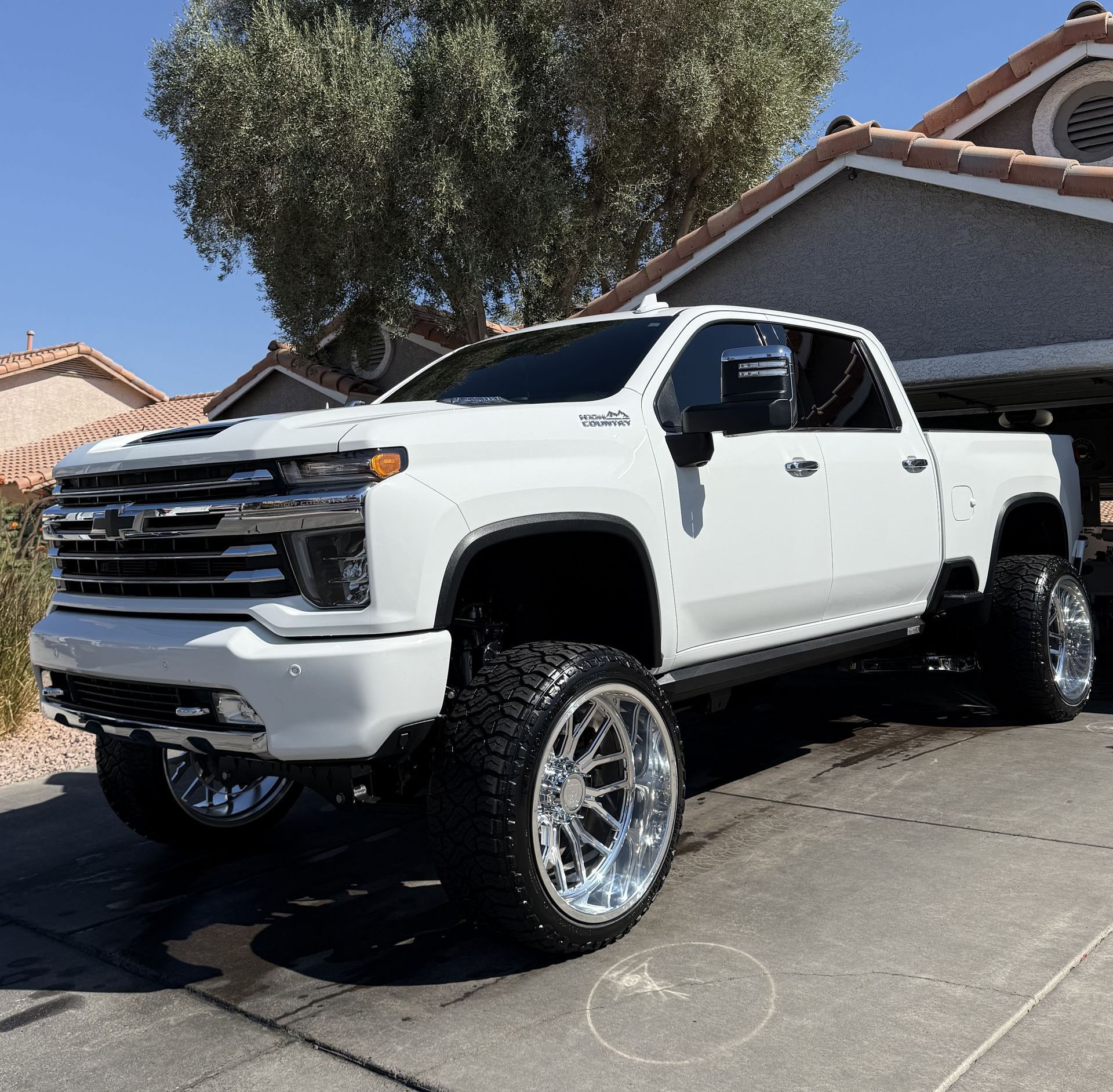 A white truck is parked in front of a house.