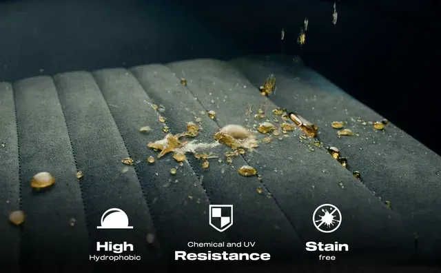 A person wearing black gloves is holding a bottle of glass shield.