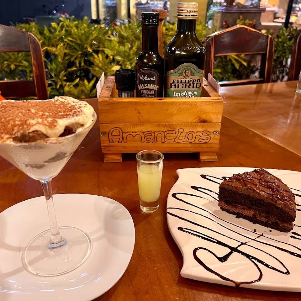 A table with a martini glass and a piece of chocolate cake on it.