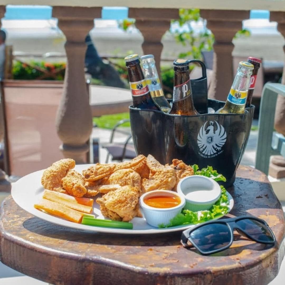 A plate of food and a bucket of beer on a table