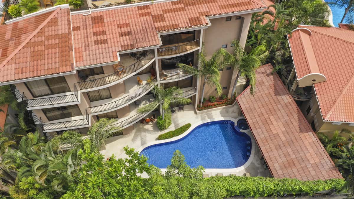An aerial view of a building with a pool in front of it