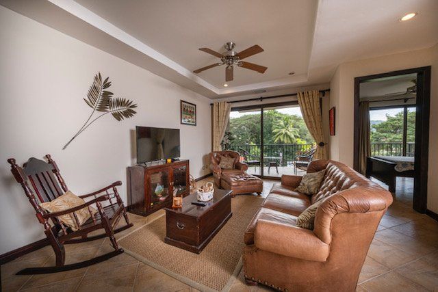 A living room with a couch , rocking chair , coffee table and television.