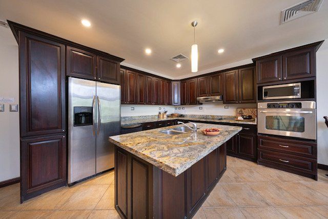 A kitchen with a large island and stainless steel appliances