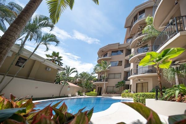 A large building with a swimming pool in front of it