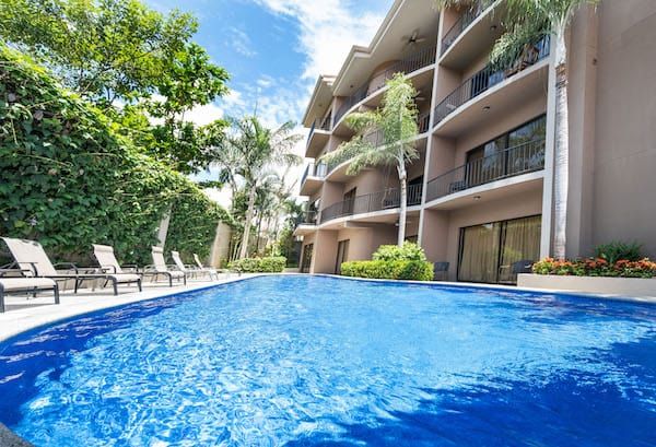There is a large swimming pool in front of a building.