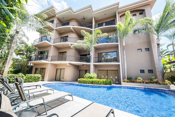 A large building with a swimming pool in front of it.