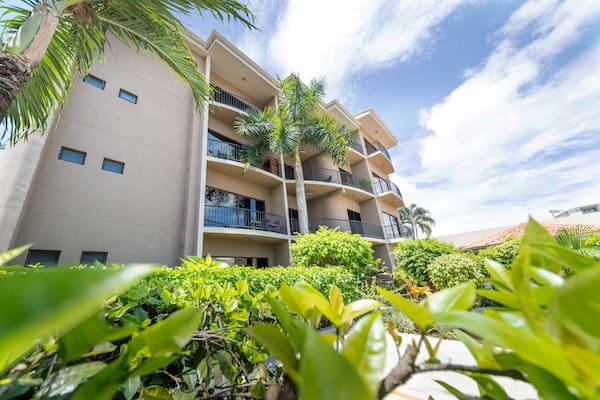 A large apartment building with palm trees in front of it.