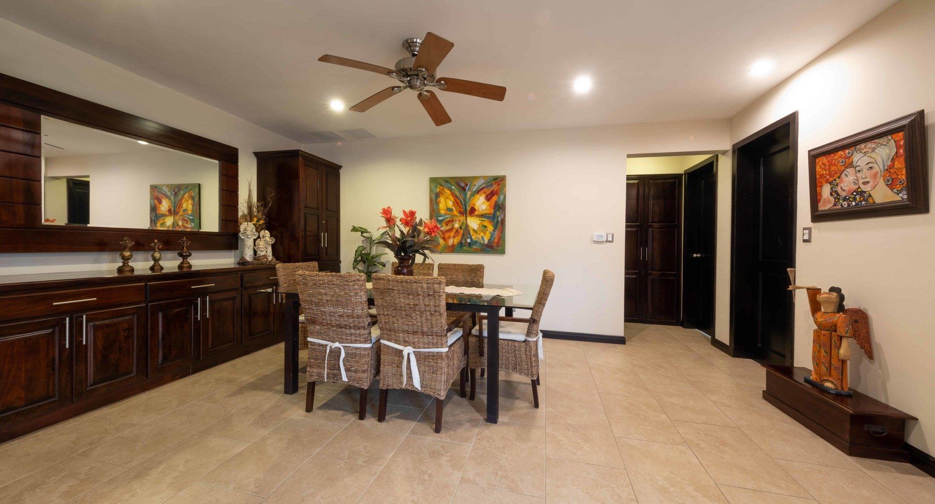 A dining room with a table and chairs and a ceiling fan