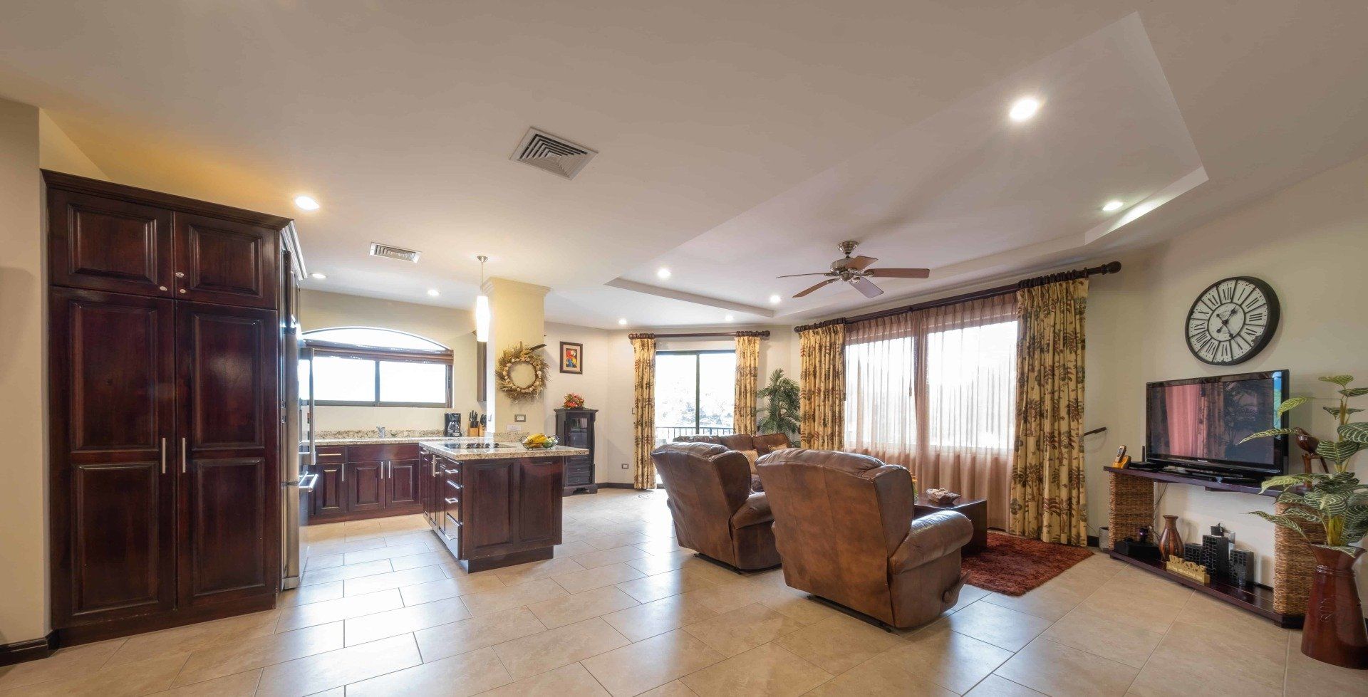 A living room with a lot of furniture and a clock on the wall