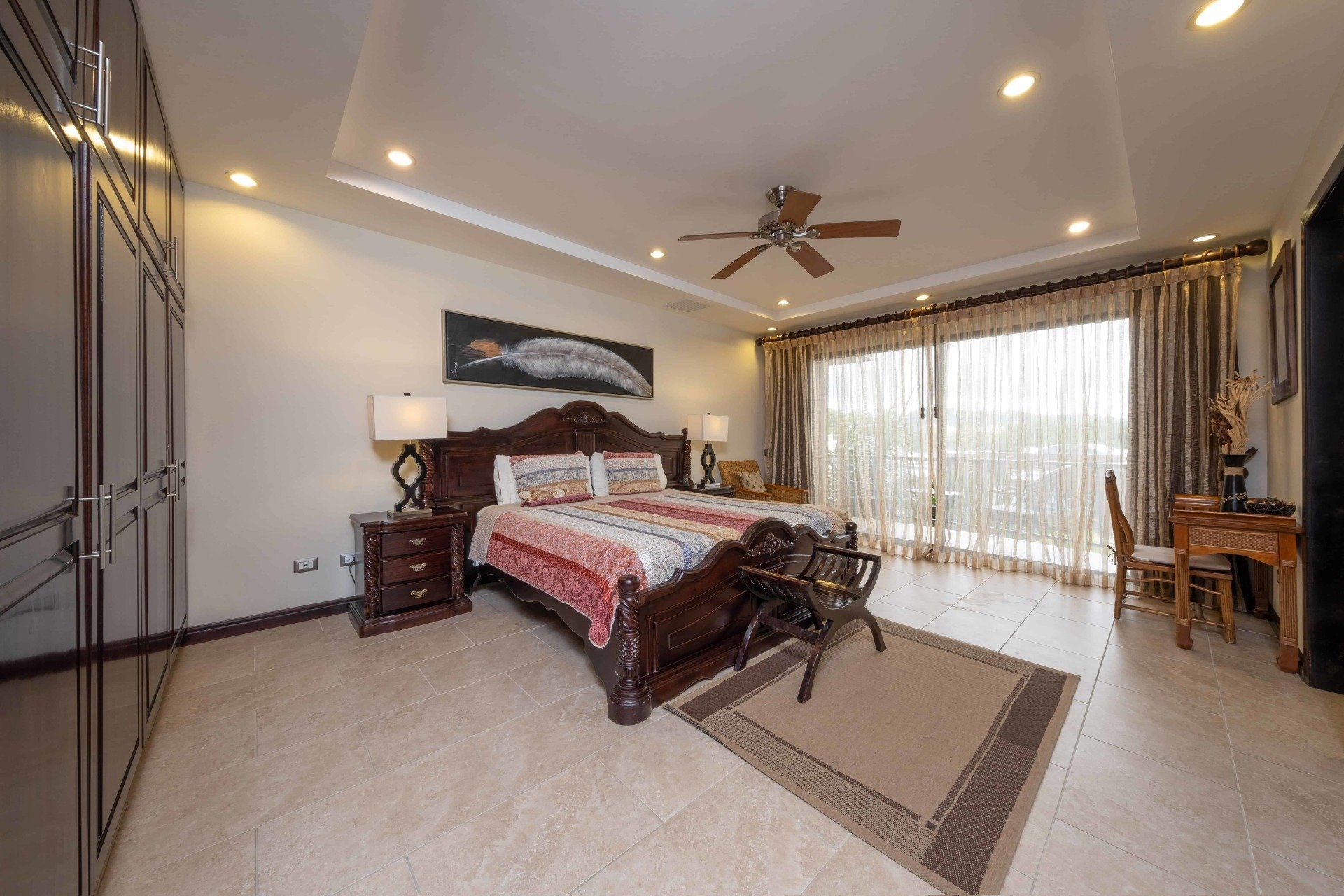 A large bedroom with a king size bed and a ceiling fan.