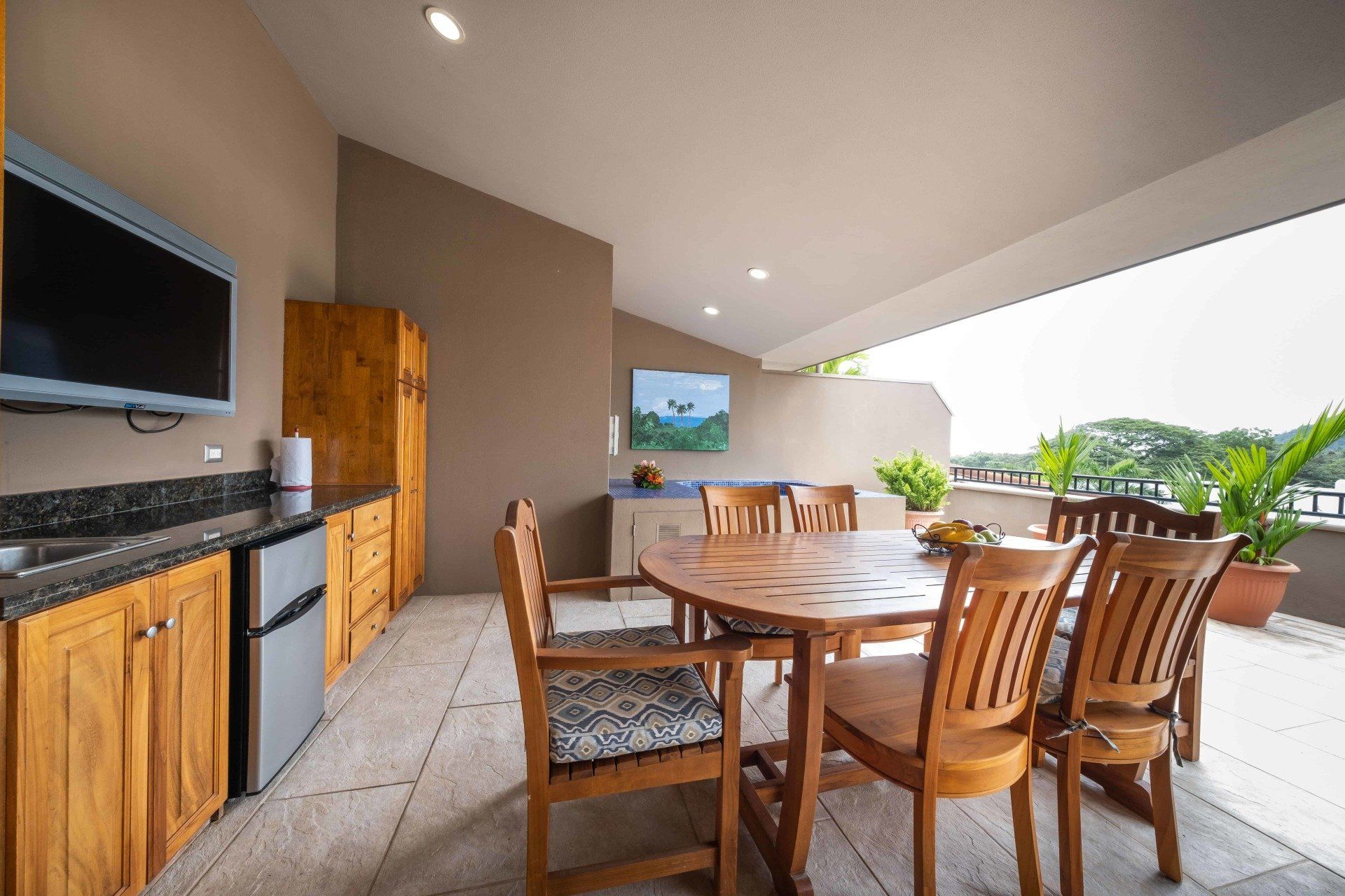 A kitchen with a table and chairs and a flat screen tv