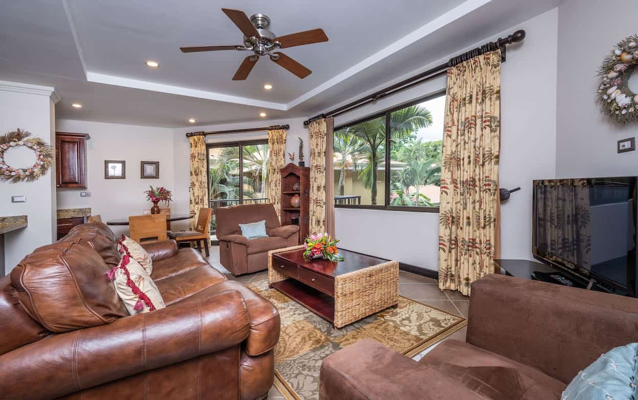A living room filled with furniture and a ceiling fan.