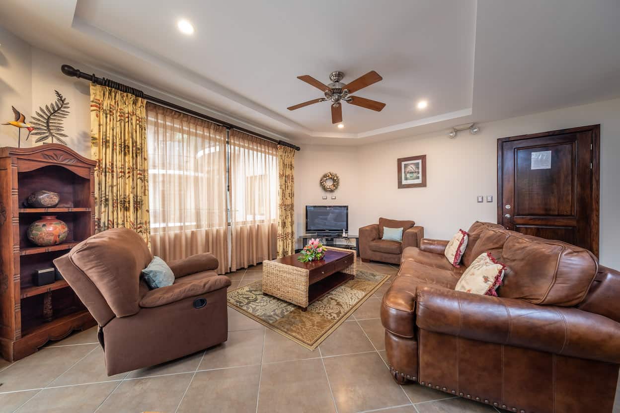 A living room filled with furniture and a ceiling fan.