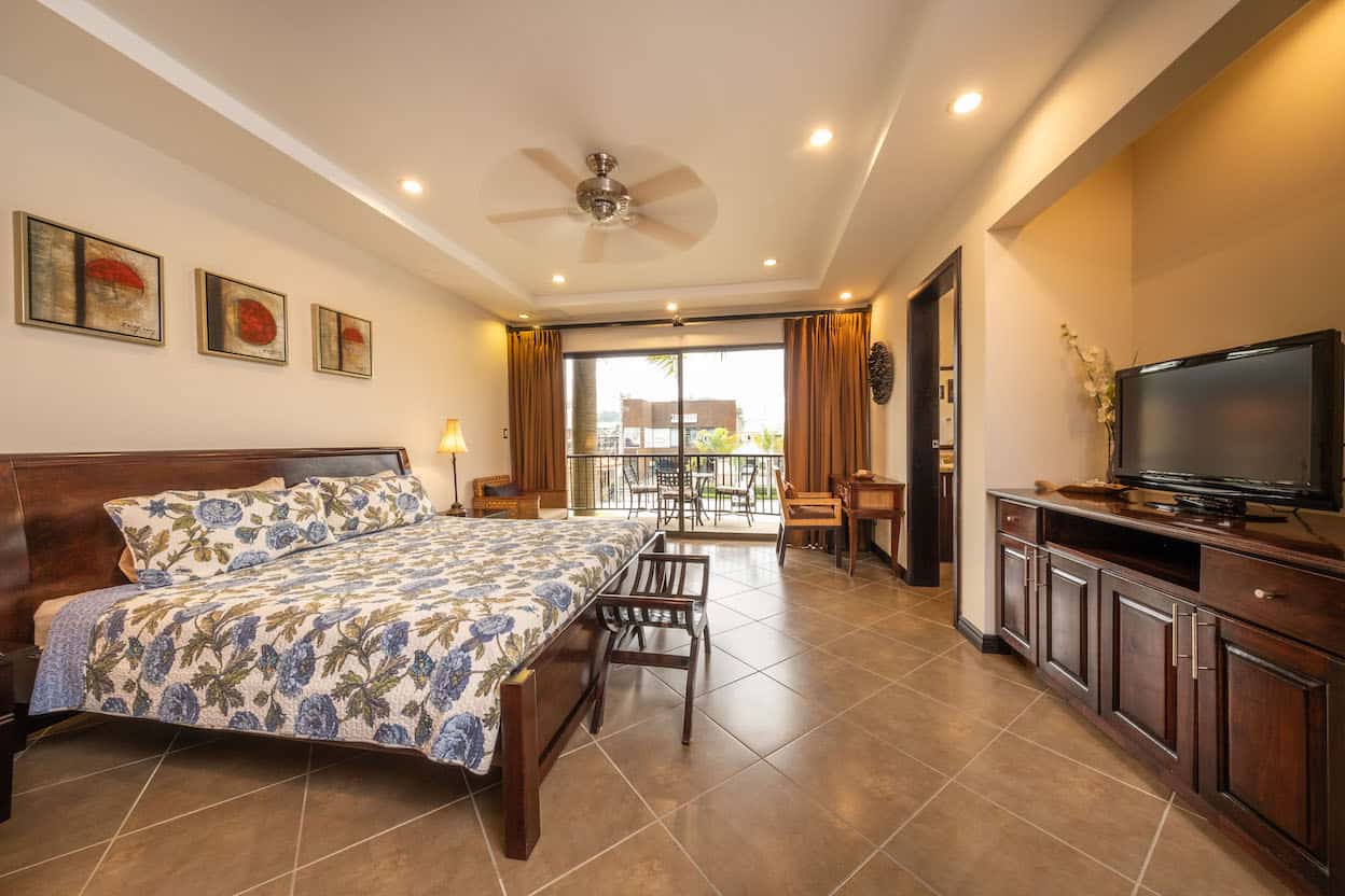 A hotel room with a large bed and a flat screen tv