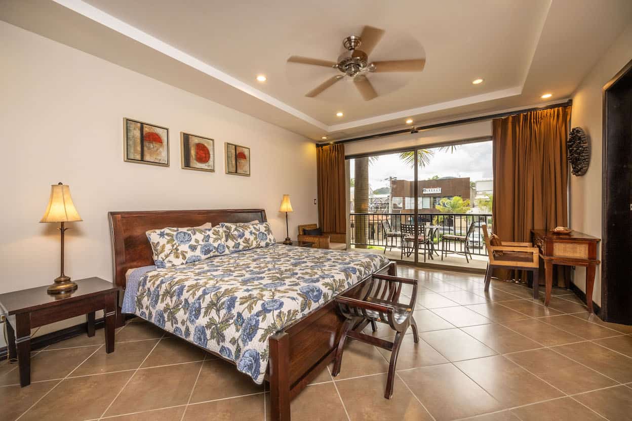 A bedroom with a large bed and a ceiling fan.