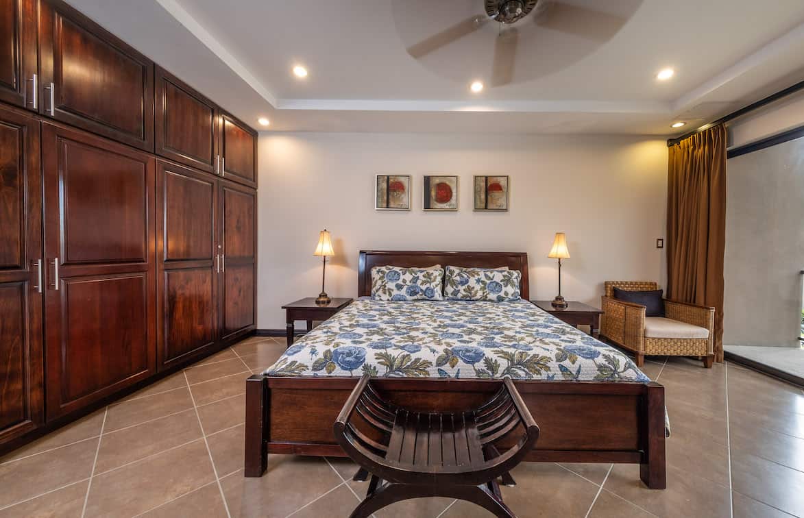 A bedroom with a large bed and a ceiling fan