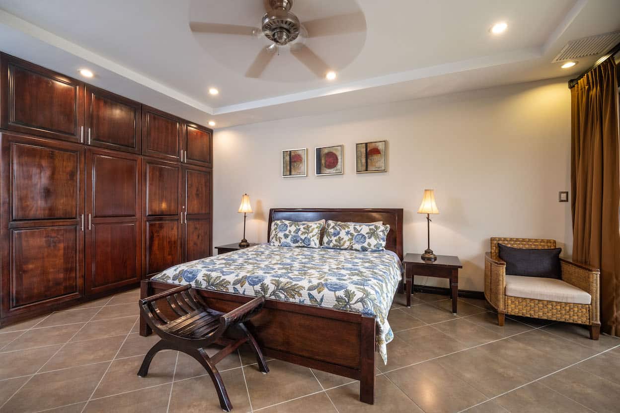 A bedroom with a large bed and a ceiling fan