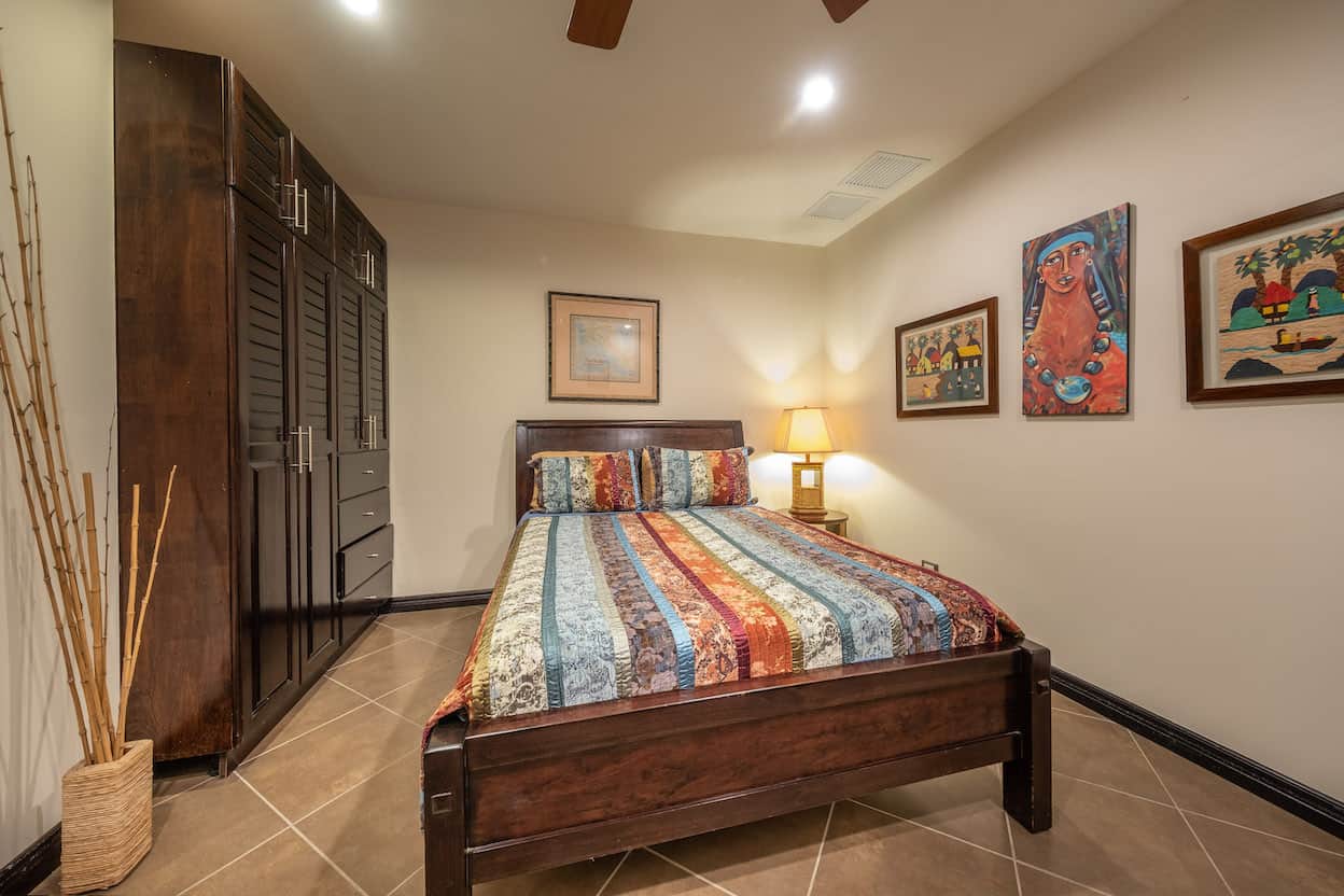 A bedroom with a bed and a ceiling fan