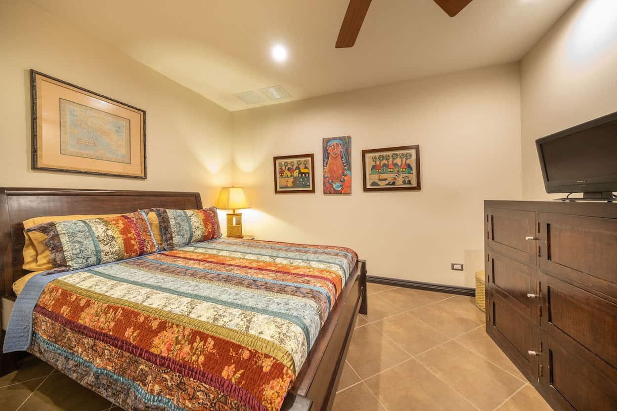 A bedroom with a king size bed , dresser , and television.