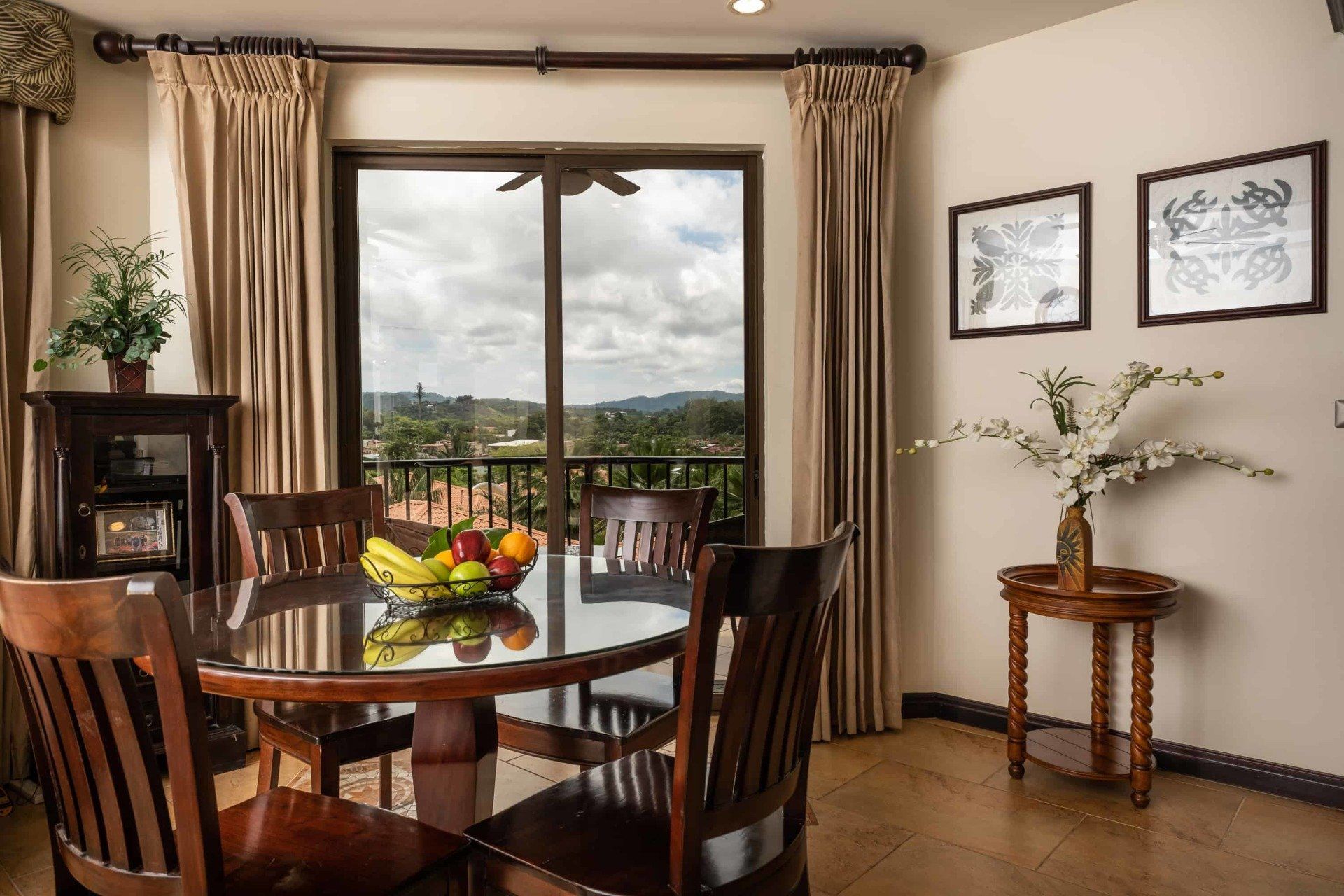 A dining room table with a bowl of fruit on it