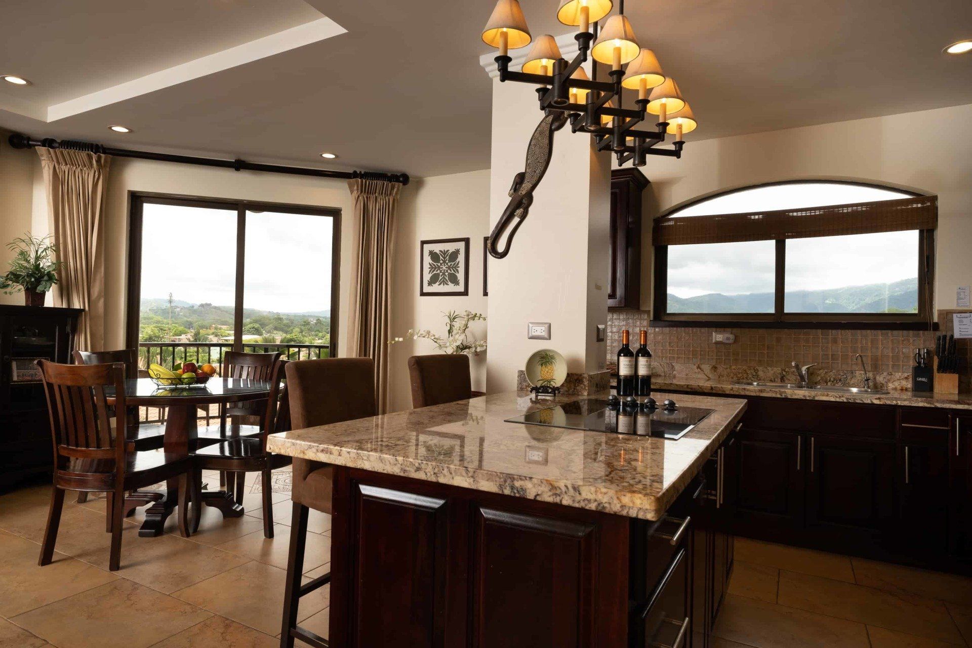 A kitchen with a large island and a chandelier hanging from the ceiling