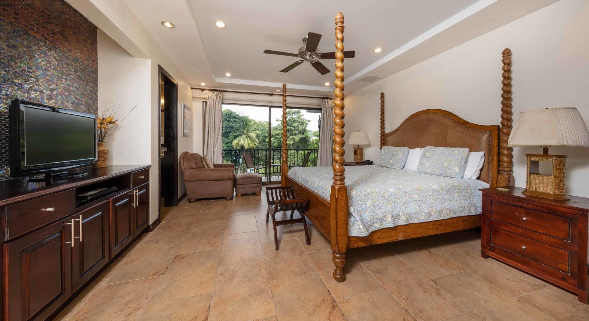 A bedroom with a four poster bed and a flat screen tv