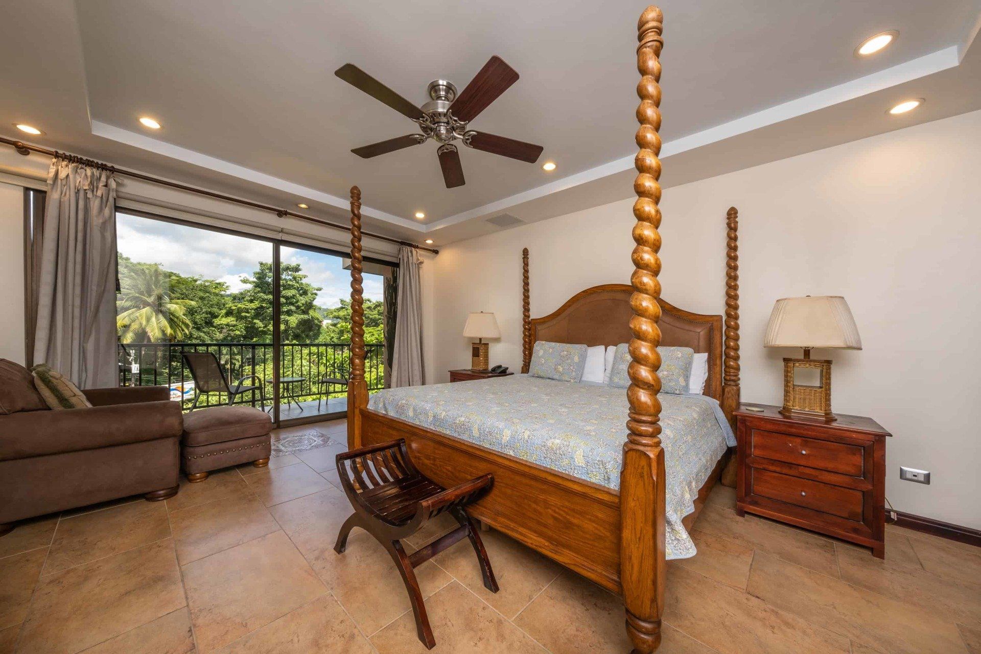 A bedroom with a four poster bed and a ceiling fan.