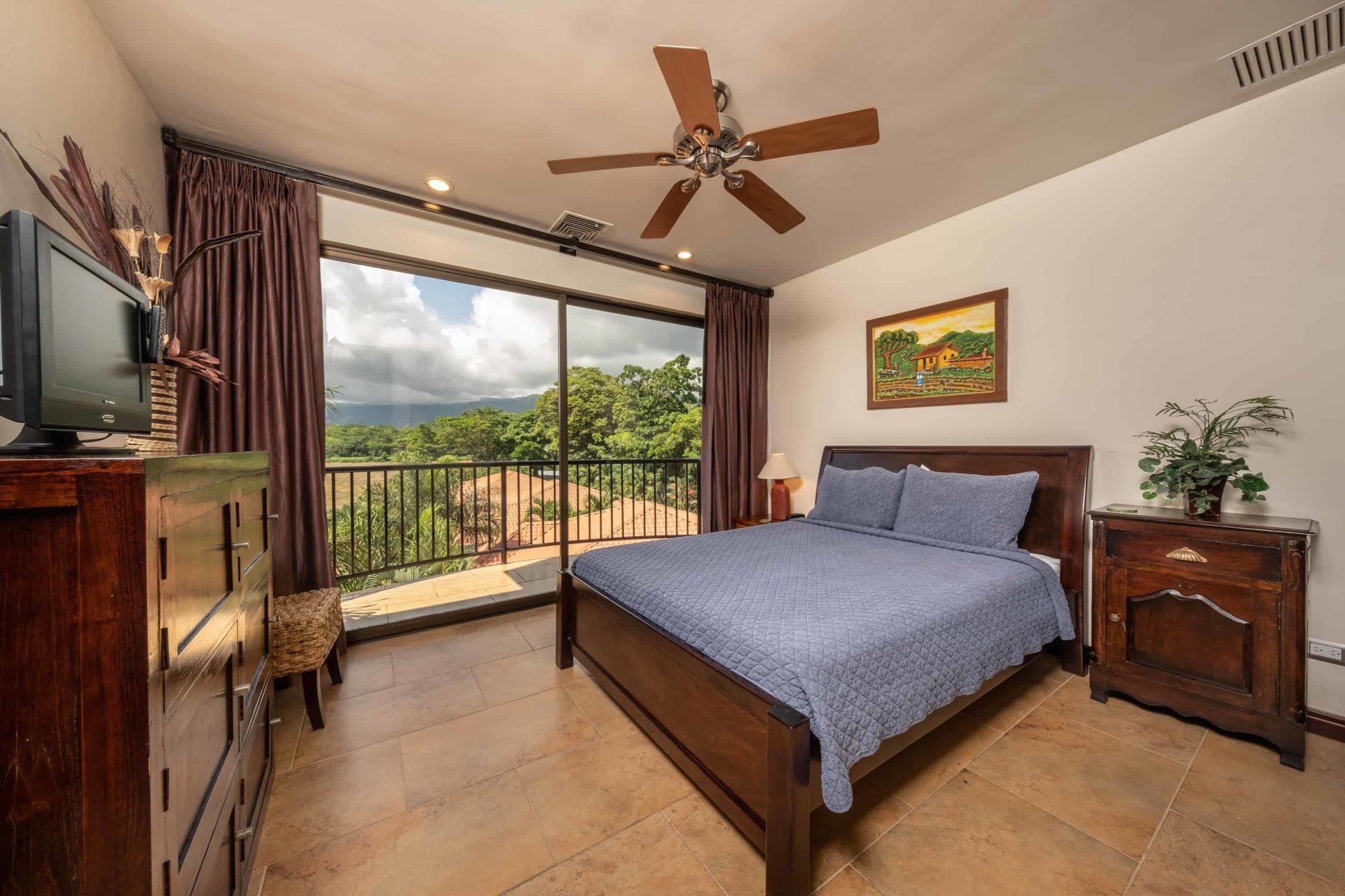 A bedroom with a large bed and a ceiling fan