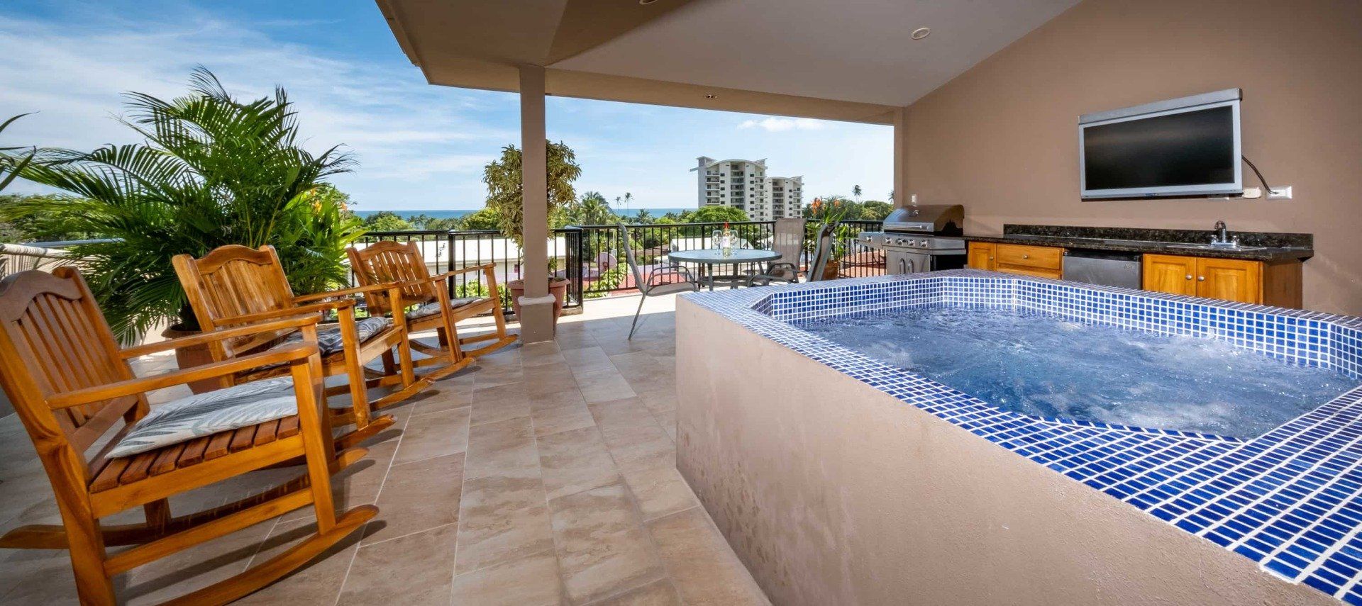 A patio with rocking chairs and a hot tub.
