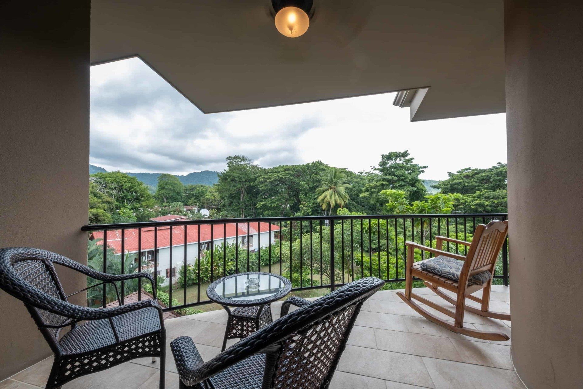 A balcony with two rocking chairs and a table