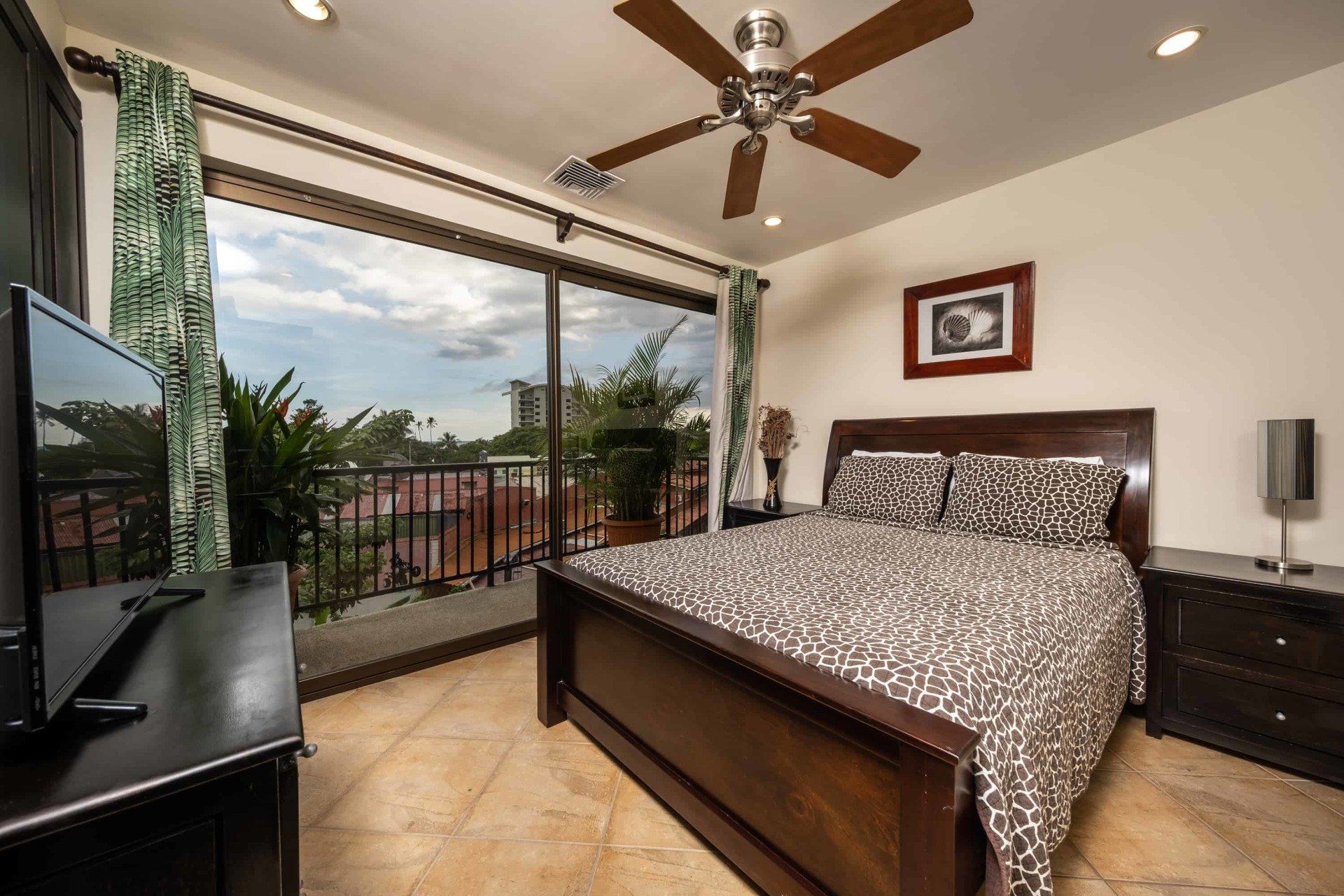 A bedroom with a large bed and a ceiling fan