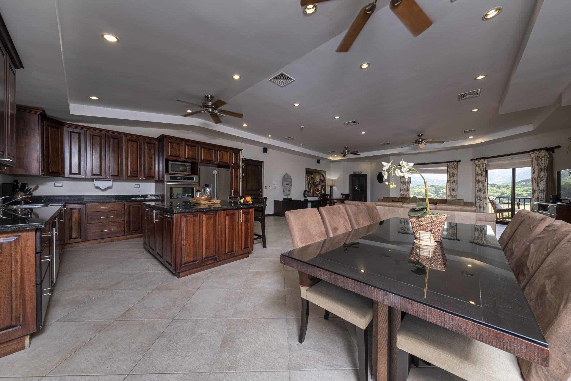 A kitchen with a dining table and chairs and a ceiling fan