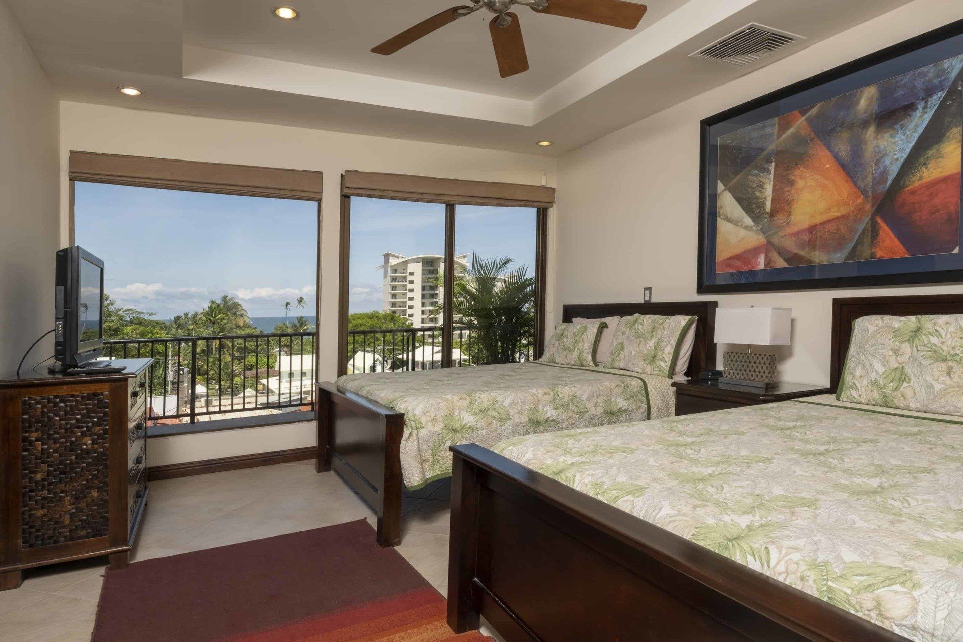 A hotel room with two beds and a painting on the wall