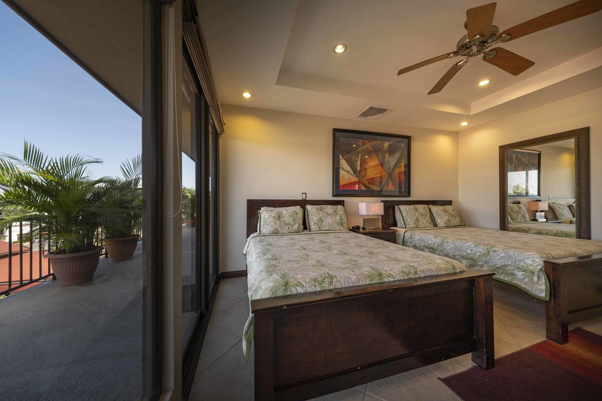 A bedroom with two beds and a ceiling fan