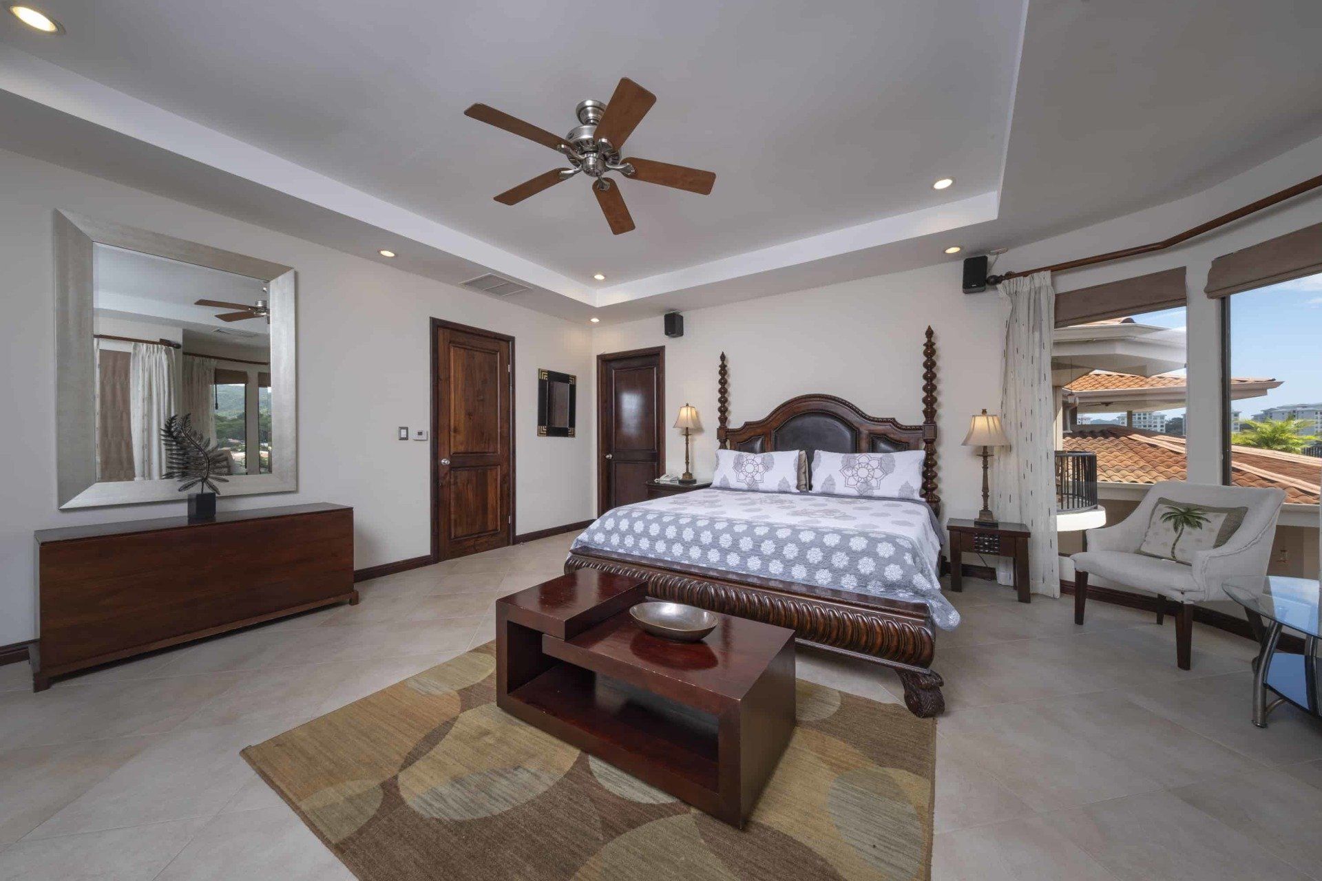 A bedroom with a king size bed and a ceiling fan