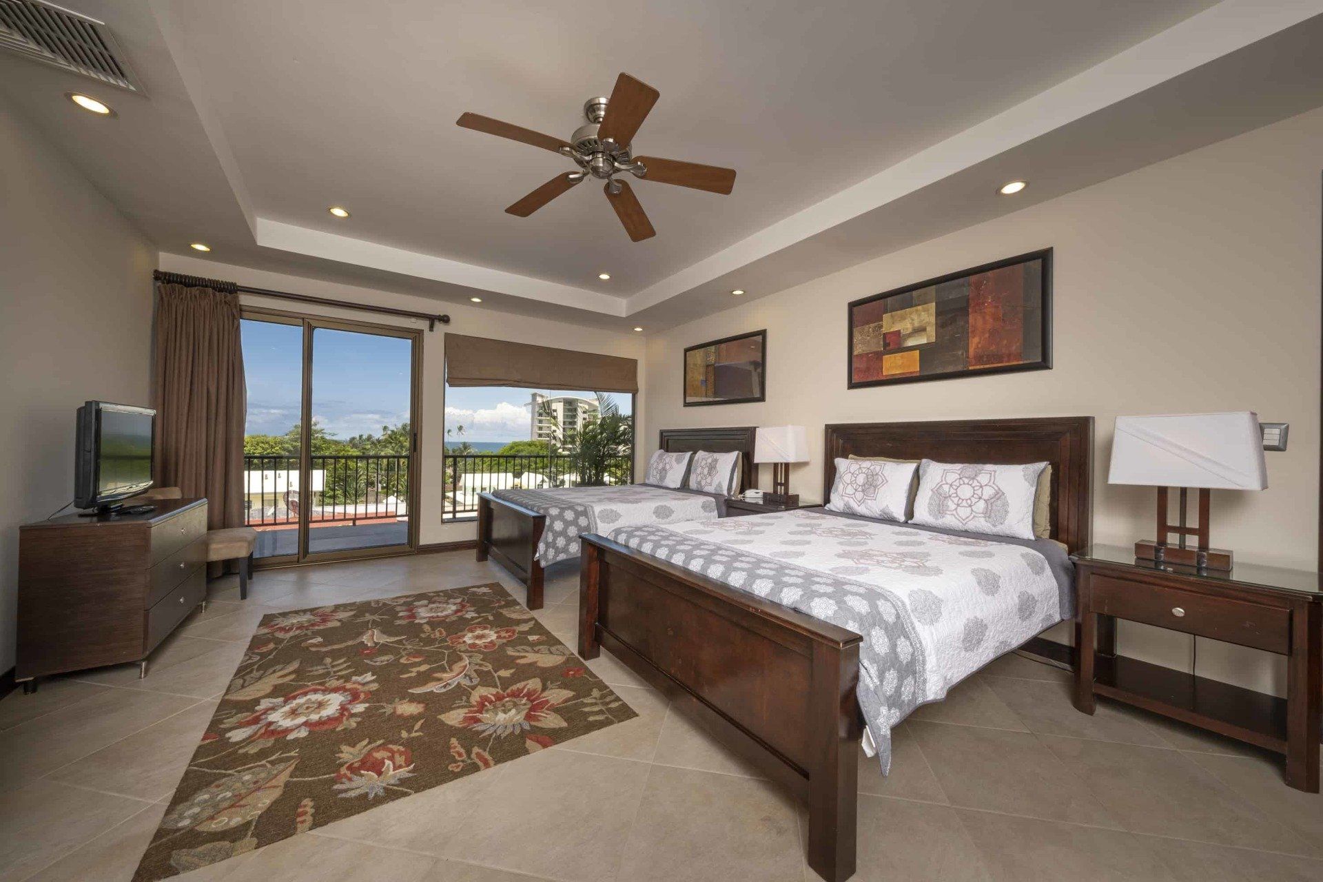 A bedroom with two beds and a ceiling fan