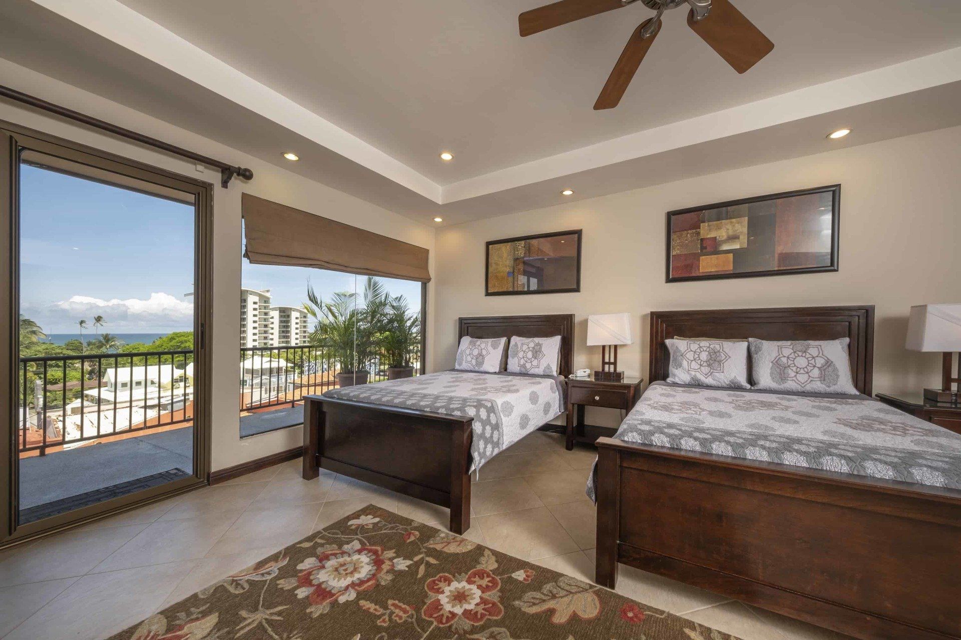 A bedroom with two beds and a ceiling fan