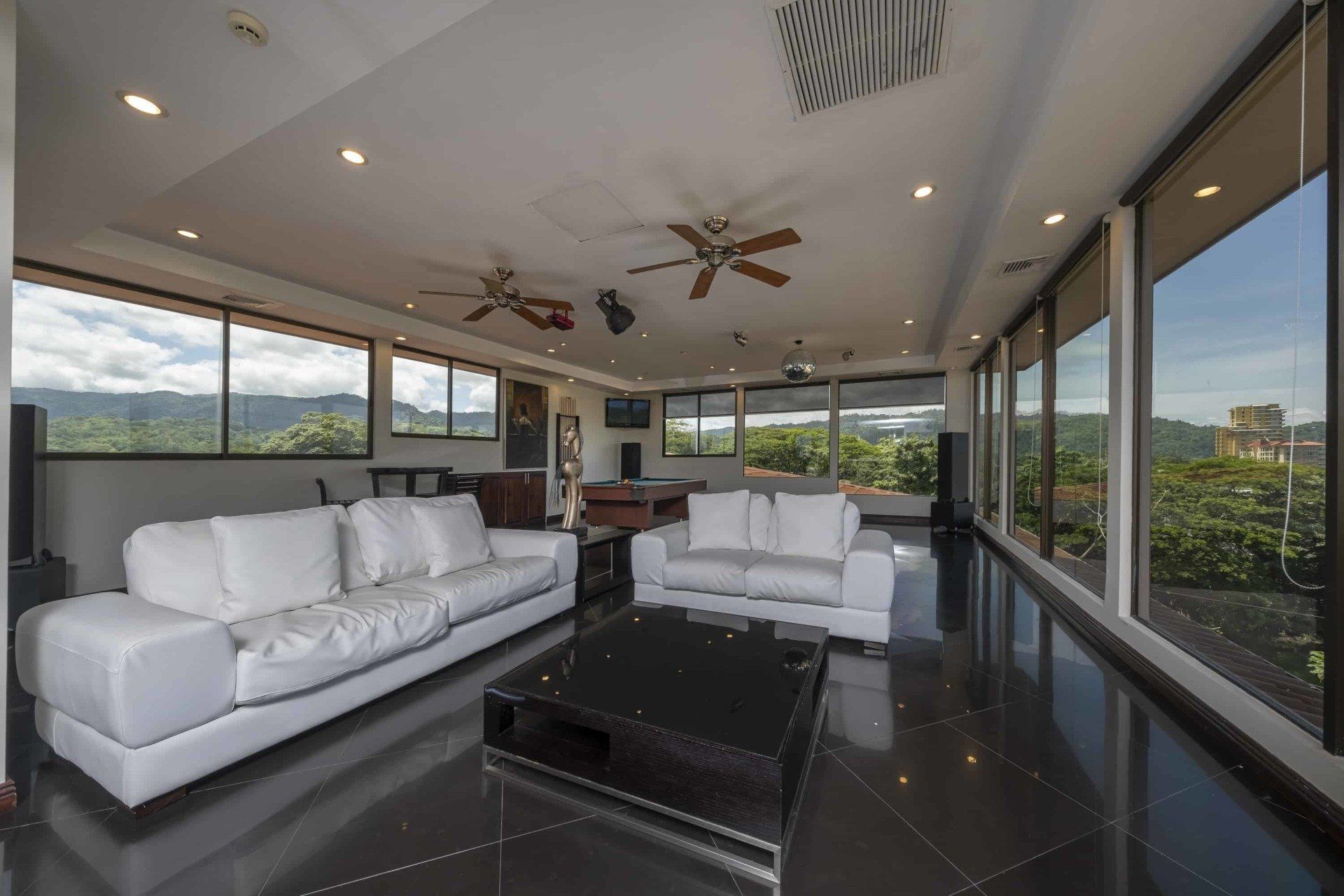 A living room with two white couches and a black coffee table