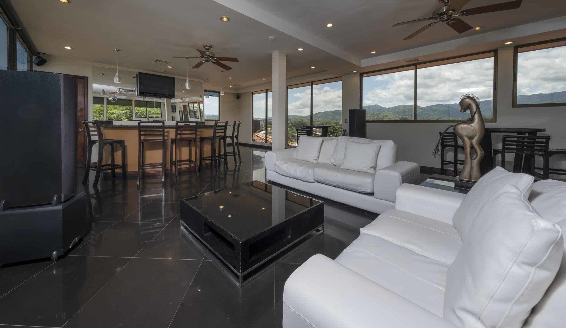 A living room with white furniture and a black coffee table