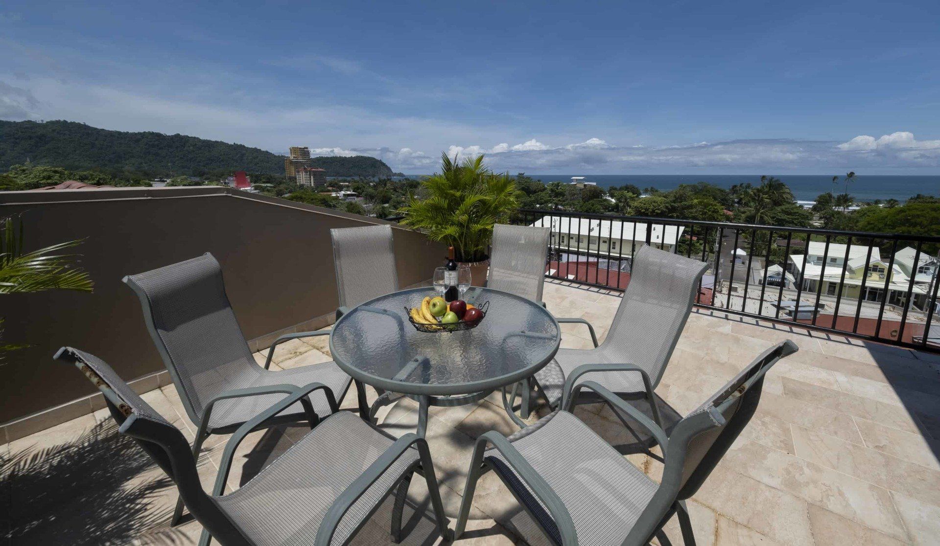 A table and chairs on a balcony overlooking the ocean
