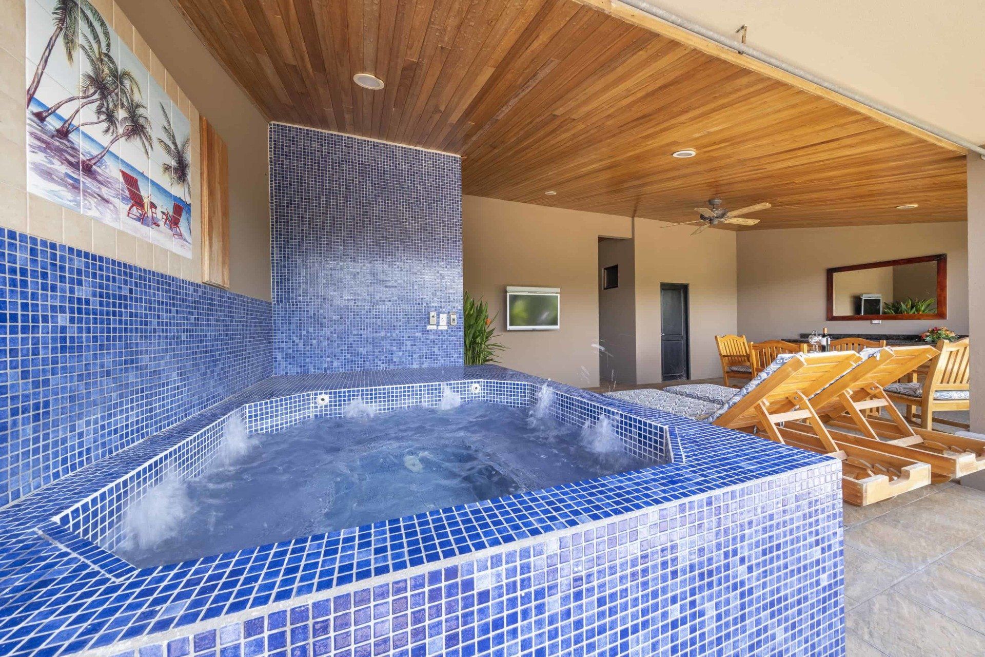 A jacuzzi in a room with a picture of a beach on the wall
