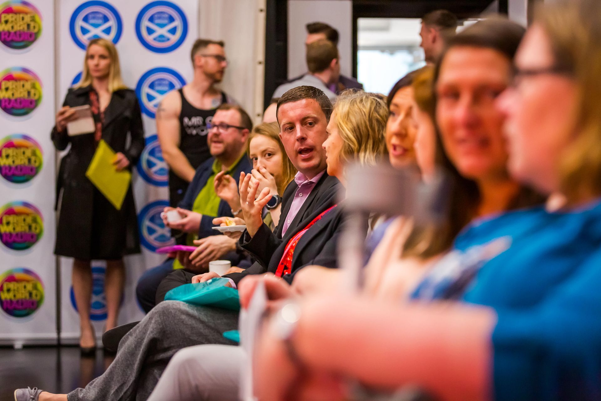A group of people are sitting in a row at a conference.