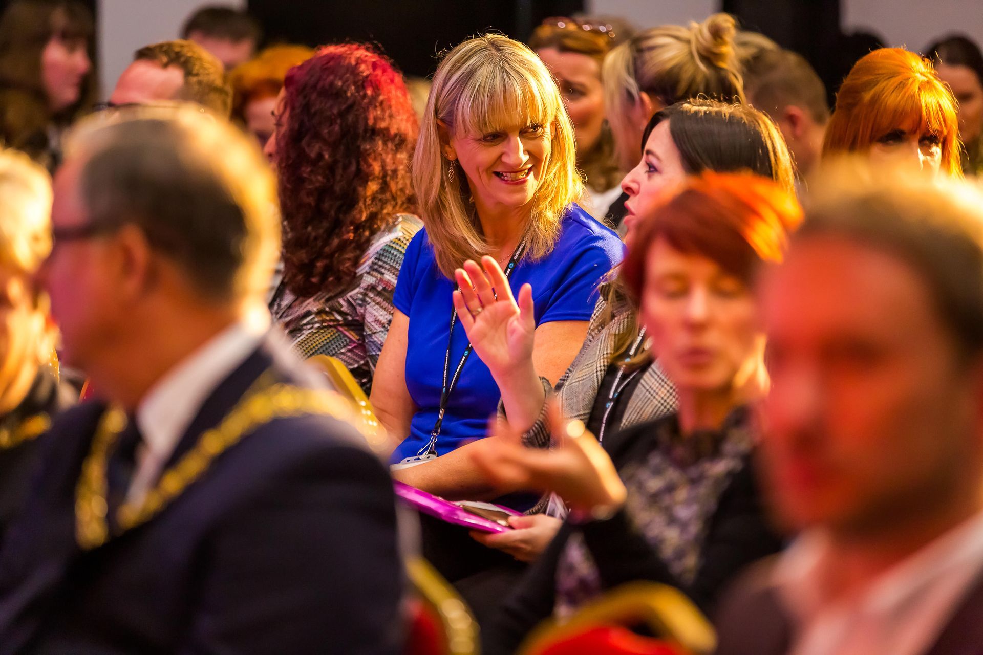 A group of people are sitting in a room and applauding.