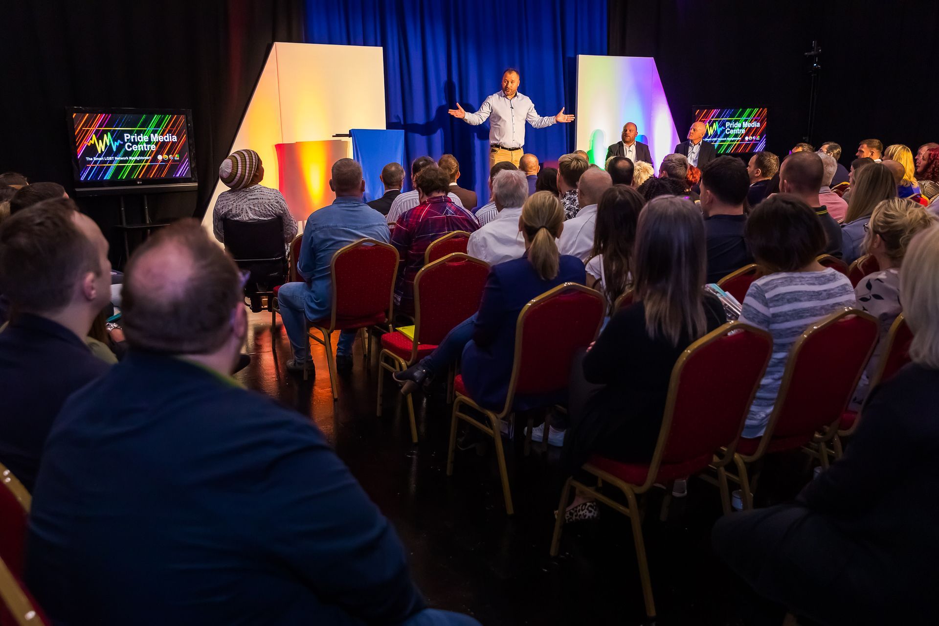 A man is giving a speech to a crowd of people in a conference room.