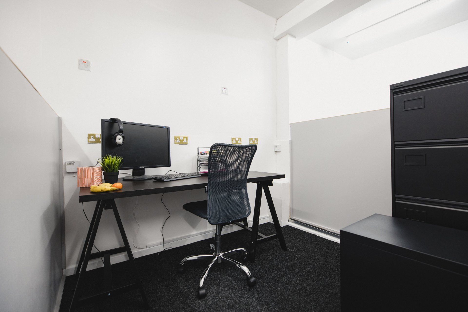 A small office with a desk and chair and a computer on it