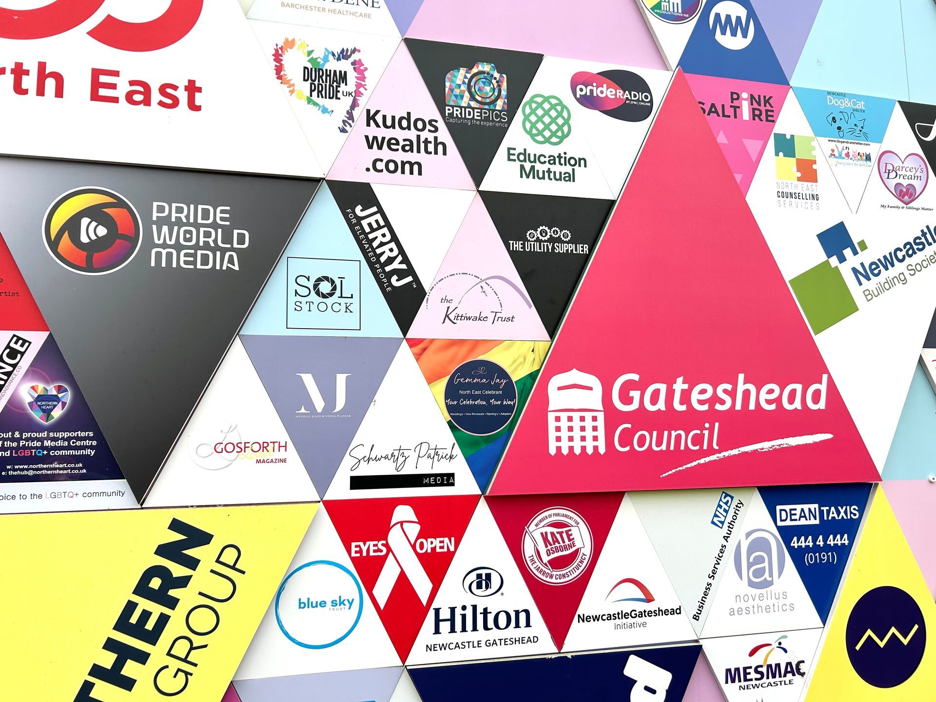 a wall of triangles with logos on them including one for gateshead council