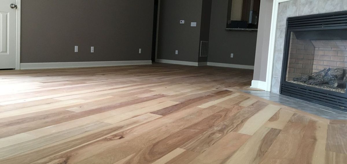 A living room with hardwood floors and a fireplace.