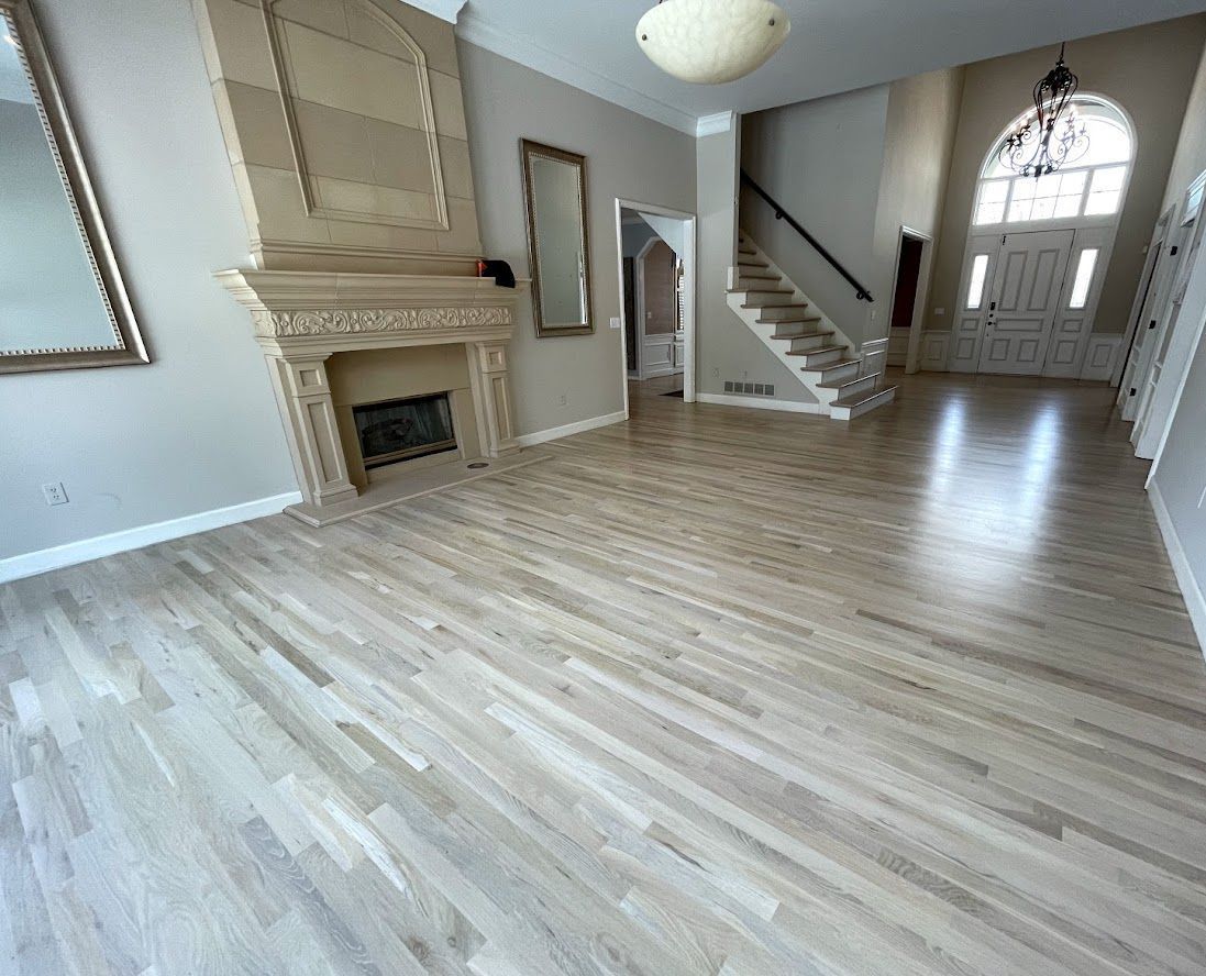 A living room with hardwood floors , a fireplace and stairs.
